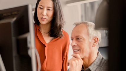 Woman and man both looking at computer screen